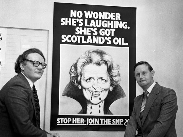 Colin Bell and (right) Gordon Wilson MP with an Scottish National Party 'recruitment' poster. The poster shows Margaret Thatcher as a vampire with the message: No wonder she's laughing. She's got Scotland's oil. Stop her - join the SNP.