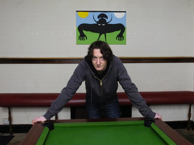 Jeff Boss at The Shakespeare pub on Gibraltar Street, Sheffield, standing in front of a ghoulish figure in the pool room where people have reported seeing ghosts