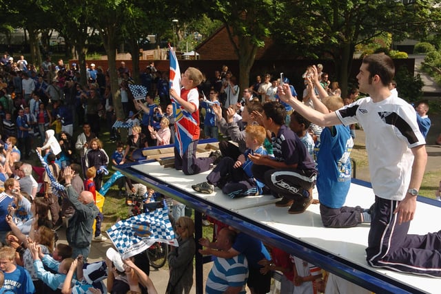 Children up high on the roof of a bus stop to see the Pompey parade bus pass by and capture the historic moment. Picture: Malcolm Wells 082235-126