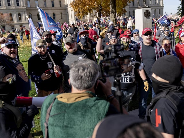Trump supporters, rear, demonstrating the election results, argue with counter protestors at the State Capitol in Lansing, Mich (AP Photo/David Goldman)