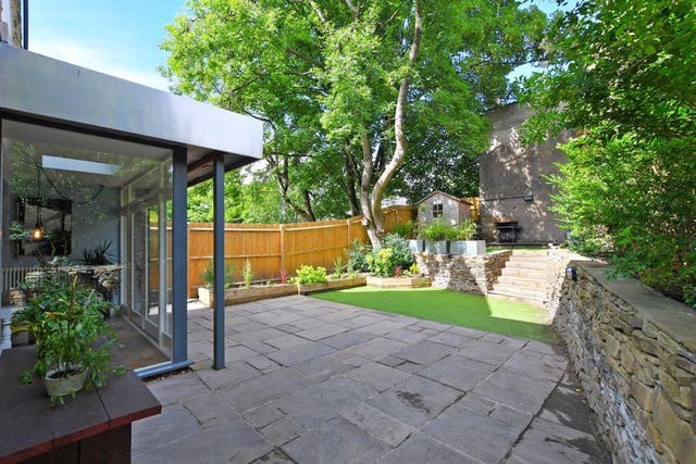 To the rear of the property is a stone entertaining patio which extends to the side, tiered artificial lawns, a decked terrace and a variety of shrubs and bushes.