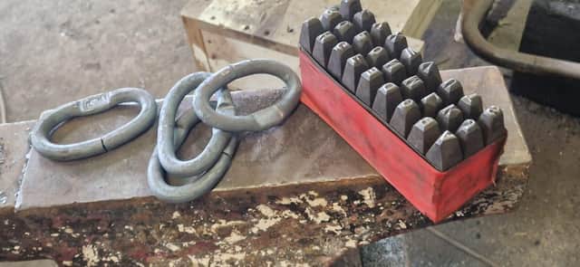 Hand-forged chain links ready for stamping on a Ridgeway Forge anvil