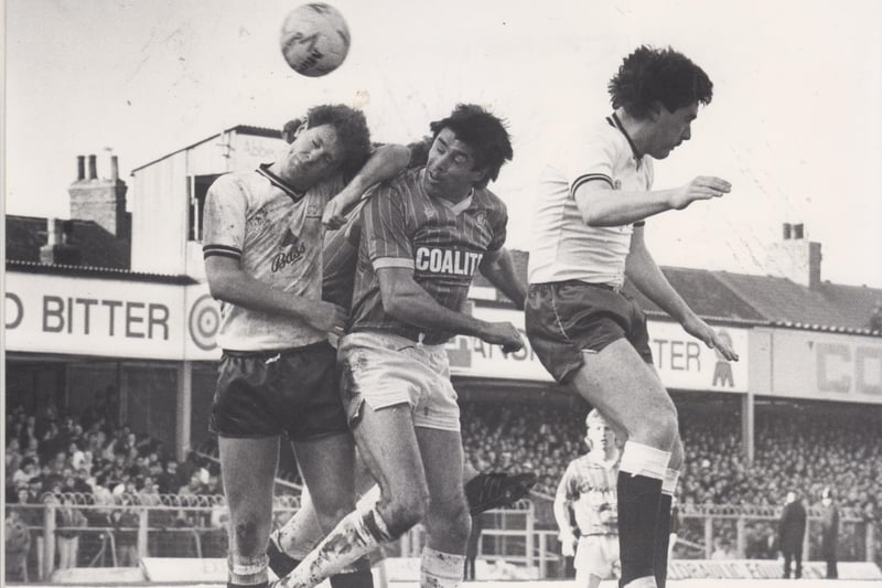 The Derby defender seemed to be having a nap on Ernie's shoulder as the Chesterfield forward heads for a goal during Chesterfield v Derby on February 22, 1986.