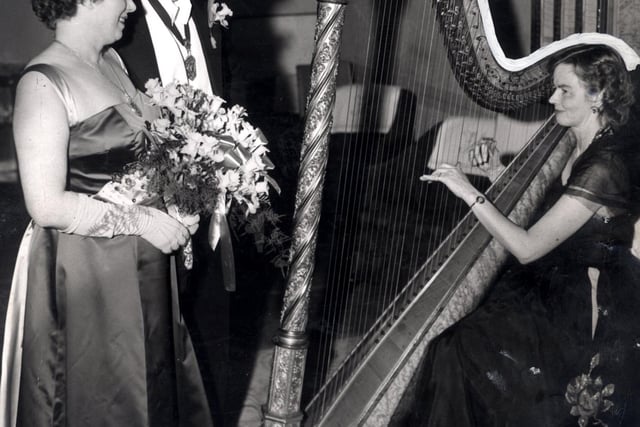 Mr Emlyn Jones, president of Sheffield and District Cambrian Society, and his wife listen to traditional Welsh melodies played by Miss Hope Hanson at the St Cavid's Day celebrations at the Grand Hotel, Sheffield, in March 1959