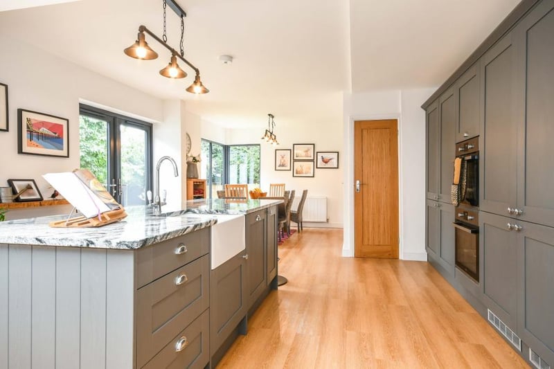 The kitchen has an integrated double oven, induction hob with an overhead extractor fan, dishwasher and full-sized integrated fridge and freezer.