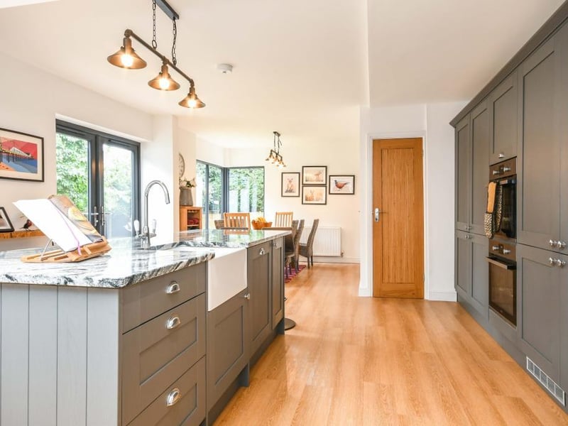 The kitchen has an integrated double oven, induction hob with an overhead extractor fan, dishwasher and full-sized integrated fridge and freezer.