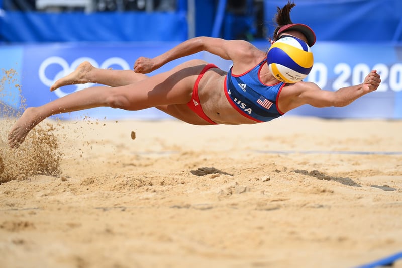 Sarah Sponcil #2 of Team United States dives to return the ball against Team Latvia during the Women's Preliminary - Pool D beach volleyball on day three of the Tokyo 2020