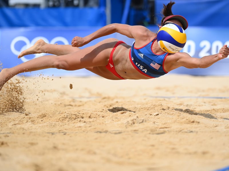 Sarah Sponcil #2 of Team United States dives to return the ball against Team Latvia during the Women's Preliminary - Pool D beach volleyball on day three of the Tokyo 2020
