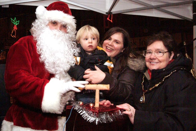 Councillor May Barsby switches on Sutton Christmas lights along with Santa and Chad competition winners Gabriel and Erika Gregory