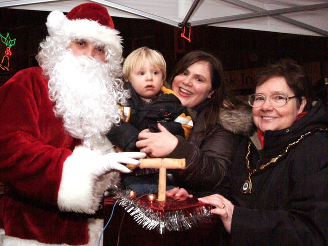 Councillor May Barsby switches on Sutton Christmas lights along with Santa and Chad competition winners Gabriel and Erika Gregory