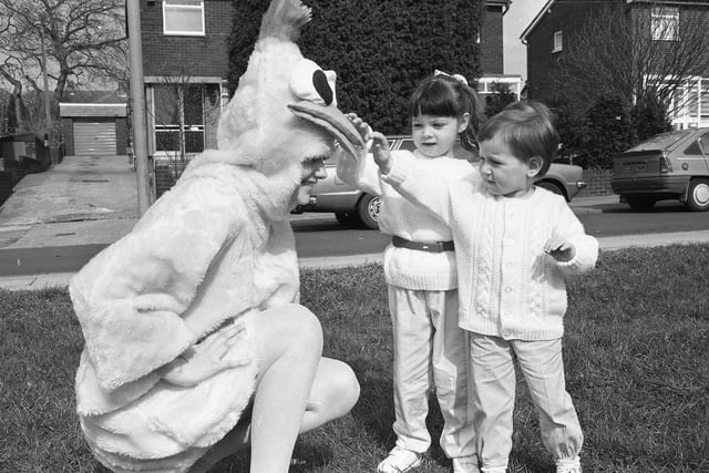 Meeting the Easter Chick at East Herrington Library, were Clare Johnson (3) and Adam Ross (2).  Library assistant Christine Winter was inside the costume in April 1987.