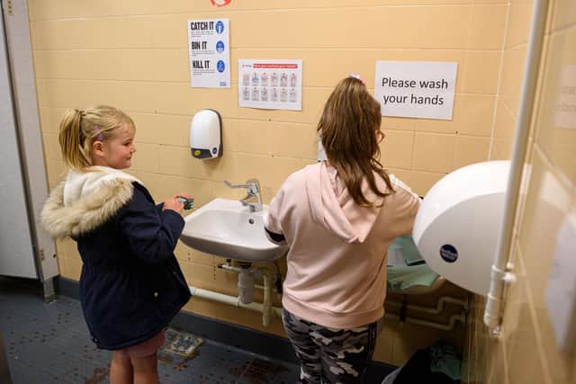 Key Stage 2 pupils wash their hands after taking part in outdoor physical exercise, in order to minimise the risk of passing on Coronavirus (Photo by OLI SCARFF/AFP via Getty Images)