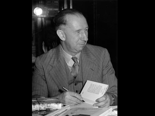 11th May 1953:  English novelist Nevil Shute (1899 - 1960) autographing books in aid of the National Fund for Polio Research at Harrod's Book Department.  (Photo by Central Press/Getty Images)