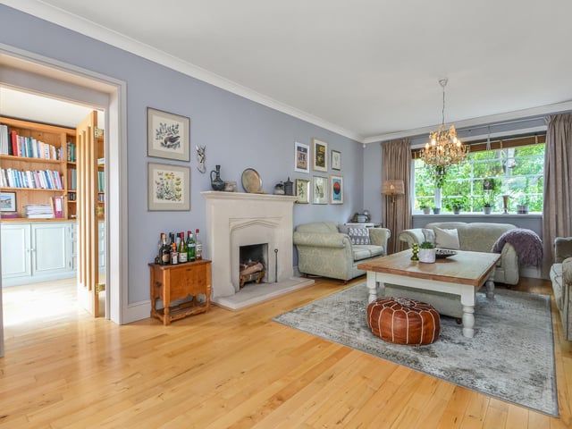 The sitting room has solid wooden flooring and a stone surround fireplace