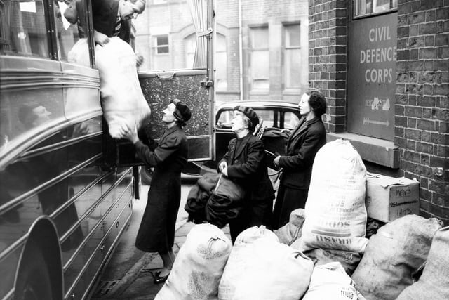 Three Women's Voluntary Service members load sacks of clothing and items for refugees from Hungary into a bus in Sheffield in 1956