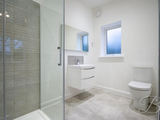 Fitted with a modern suite, shower cubicle, low level WC and wash basin set into vanity unit.