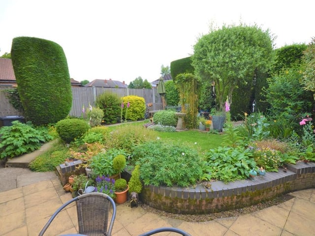 Rear garden - Wrought iron gates to either side of the property give access to a fully enclosed and private rear garden, having mature trees, shrubs and flowers frame various patio seating areas and well kept lawn, there is access back into the breakfast room and conservatory.