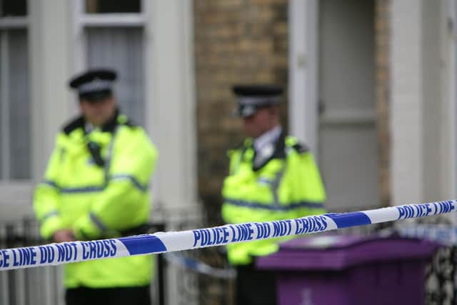 Police officers stand outside a house (Photo by Christopher Furlong/Getty Images)