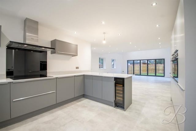 The kitchen has a range of integrated appliances including double eye level oven, fridge, freezer, wine cooler, dishwasher and induction hob with extractor fan over.