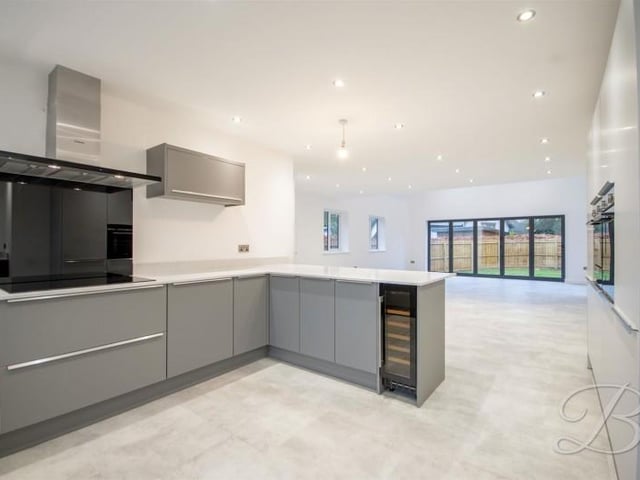 The kitchen has a range of integrated appliances including double eye level oven, fridge, freezer, wine cooler, dishwasher and induction hob with extractor fan over.