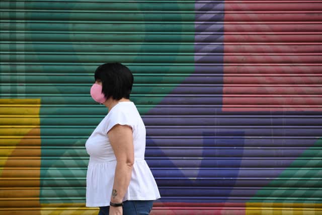 A shopper wearing a face mask walks in the city centre of Sheffield (Photo by OLI SCARFF/AFP via Getty Images)