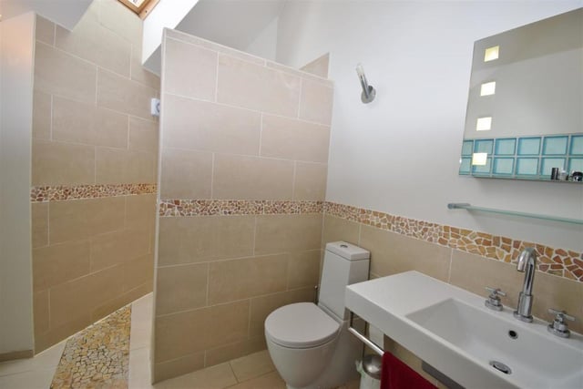 The en suite to the master bedroom comprises a modern wet room with a walk-in shower, wash hand basin and low-flush WC. There's also a feature glass block wall, back-lit mirror, heated towel-rail and tiled floor.