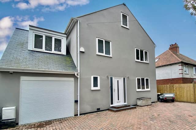 The front of the property boasts a block-paved driveway with parking for at least three cars.