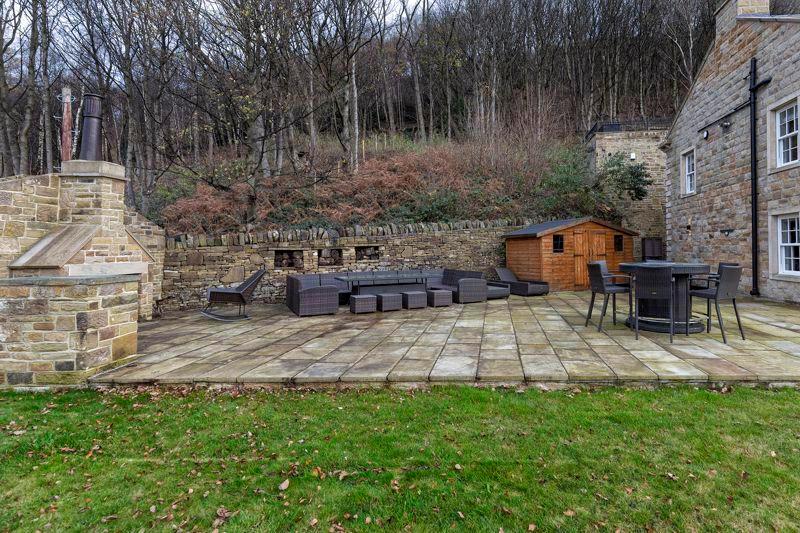 Spacious outdoor entertaining terrace with built-in barbecue and stone-flagged patio.