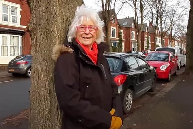 Heather Mitchell leaning against one of the trees on Meersbrook Park Road, Sheffield that was saved by protesters from being felled in 2018