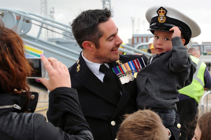 6th May 2015. HMS Dragon homecoming. CPO James Hopkins passes his hat to his son Blake Hopkins. 

On a very windy morning HMS Dragon returned to Portsmouth from a successful six-month patrol across the Atlantic and Pacific oceans.
The Type 45 destroyer travelled 22,000 miles and visited 15 ports strengthening ties with her allies and continuing the UK’s commitment to the region.

The deployment included routine patrols of the Falkland Islands and supporting the community of Tristan De Cunha by moving stores and supplies around the island. She also worked alongside maritime forces from Africa, Europe, South America and the US in a training exercise in the Gulf of Guinea designed to improve regional cooperation and information-sharing practices, while stopping illegal activity at sea.