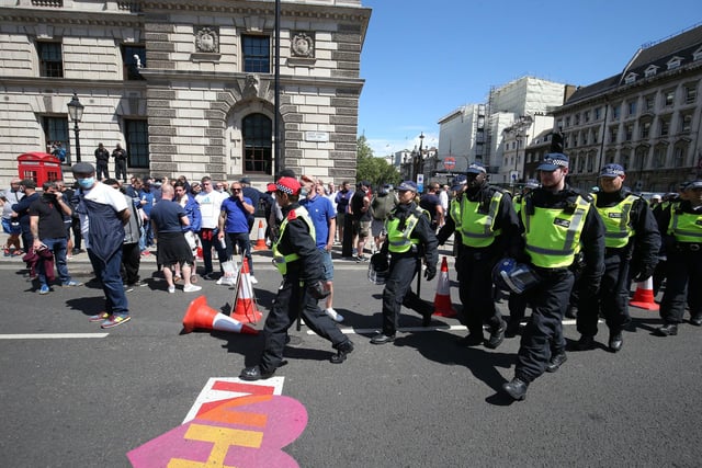 Police march past protesters in Parliament Square