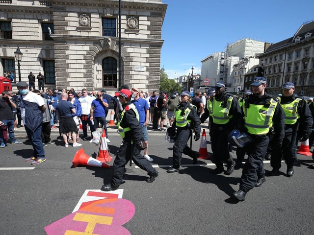 Police march past protesters in Parliament Square