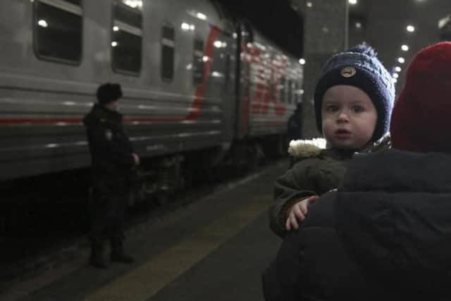 A woman carries a child as they are evacuated from the Donetsk region, the territory controlled by a pro-Russia separatist governments in eastern Ukraine, as they leave a train to be taken to temporary accommodation, at the railway station in Nizhny Novgorod, Russia. 
A long-feared Russian invasion of Ukraine appears to be imminent, if not already underway, with Russian President Vladimir Putin ordering forces into separatist regions of eastern Ukraine. (AP Photo/Roman Yarovitcyn)