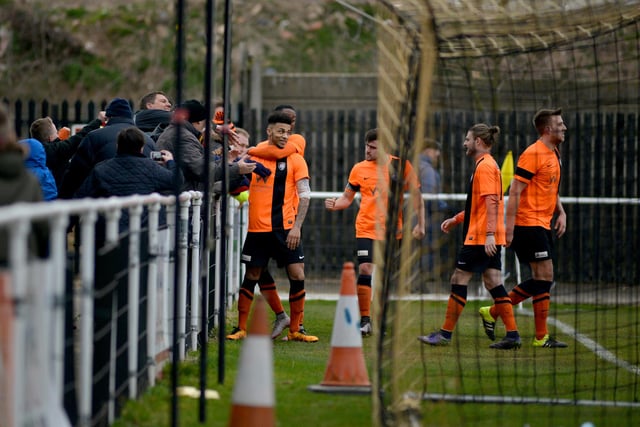 Worksop Town celebrate with fans after scoring a penalty.