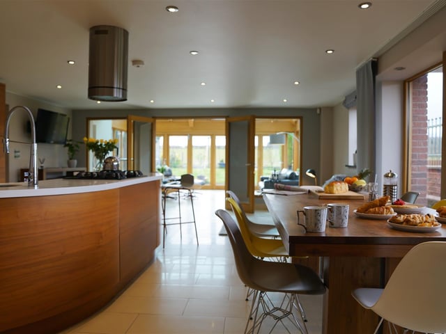 The sleek kitchen has walnut units and there is room for a large dining room table and sitting area.