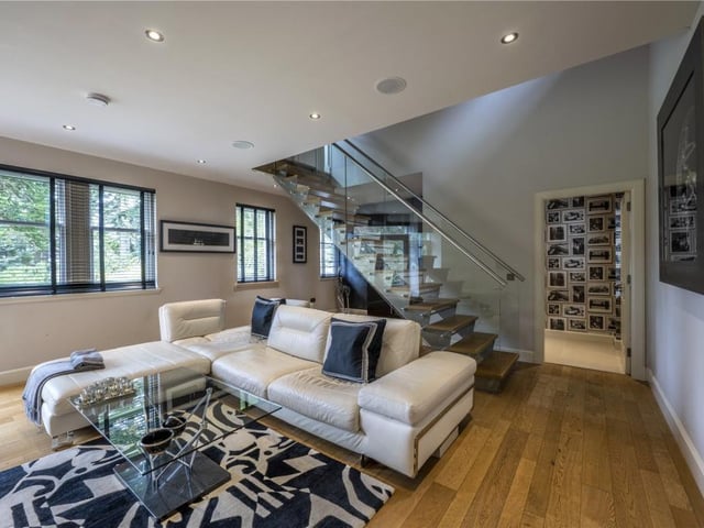 The stylish cinema room boasts a wet bar and a contemporary floating staircase with wide oak treads and glass panel balustrade, as well as its own WC.
