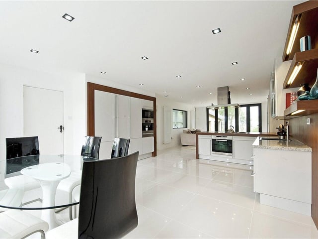The kitchen dining area is open plan and contemporary in style, with high gloss black and white wall base units and plenty of space for entertaining.