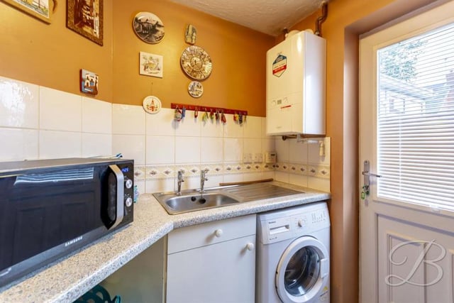 Off the kitchen is a handy utility room. It boasts storage cupboards, an inset sink and drainer, and space and plumbing for a washing machine. A door leads to the back garden.