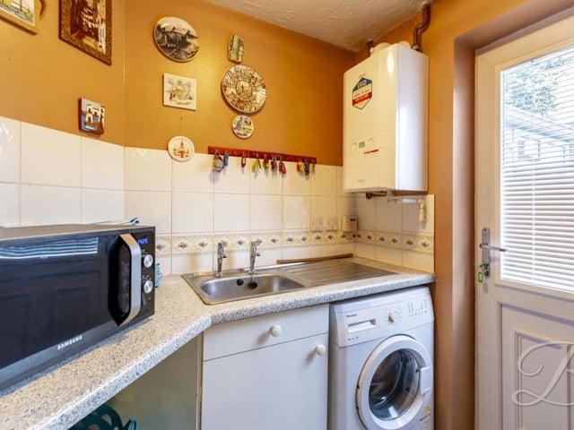 Off the kitchen is a handy utility room. It boasts storage cupboards, an inset sink and drainer, and space and plumbing for a washing machine. A door leads to the back garden.