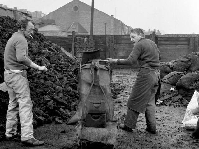 Men filling bags of peat at Haymarket Coal depot in Edinburgh.