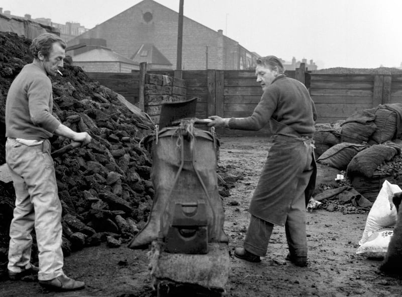 Men filling bags of peat at Haymarket Coal depot in Edinburgh.