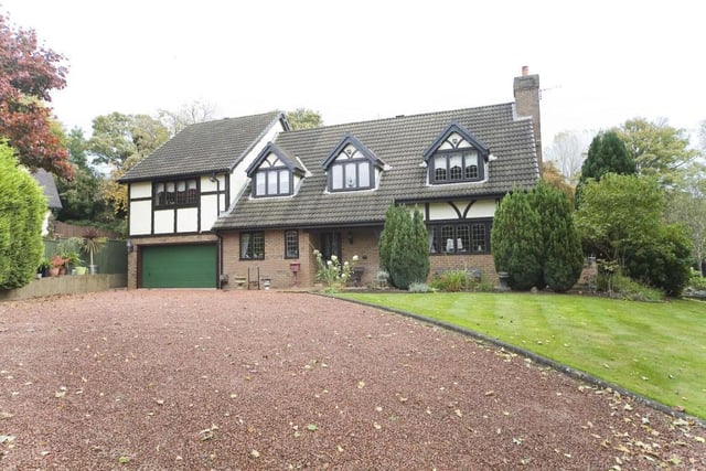 The large house has a sweeping driveway for over nine vehicles.