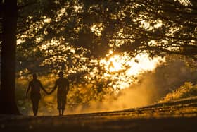 LONDON, ENGLAND - SEPTEMBER 12:  A couple walk through Richmond Park at sunset on September 12, 2014 in London, England. Much of the UK continues to enjoy mild Autumn weather with sunshine set to last for the next few days. (Photo by Justin Setterfield/Getty Images)