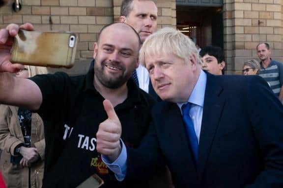 British Prime Minister Boris Johnson poses for a selfie with a member of the public during a visit to Doncaster Market on September 13, 2019 in Doncaste (Photo by Jon Super - WPA Pool/Getty Images)