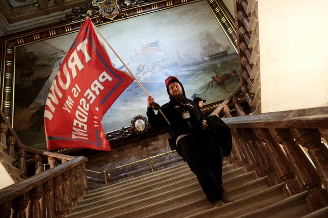 A protester holds a Trump flag inside the US Capitol Building near the Senate Chamber on January 06, 2021 in Washington, DC. Congress held a joint session today to ratify President-elect Joe Biden's 306-232 Electoral College win over President Donald Trump. A group of Republican senators said they would reject the Electoral College votes of several states unless Congress appointed a commission to audit the election results. (Photo by Win McNamee/Getty Images)