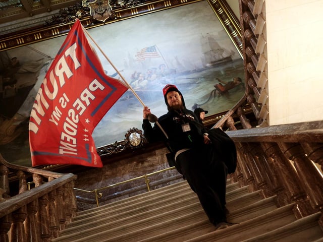 A protester holds a Trump flag inside the US Capitol Building near the Senate Chamber on January 06, 2021 in Washington, DC. Congress held a joint session today to ratify President-elect Joe Biden's 306-232 Electoral College win over President Donald Trump. A group of Republican senators said they would reject the Electoral College votes of several states unless Congress appointed a commission to audit the election results. (Photo by Win McNamee/Getty Images)