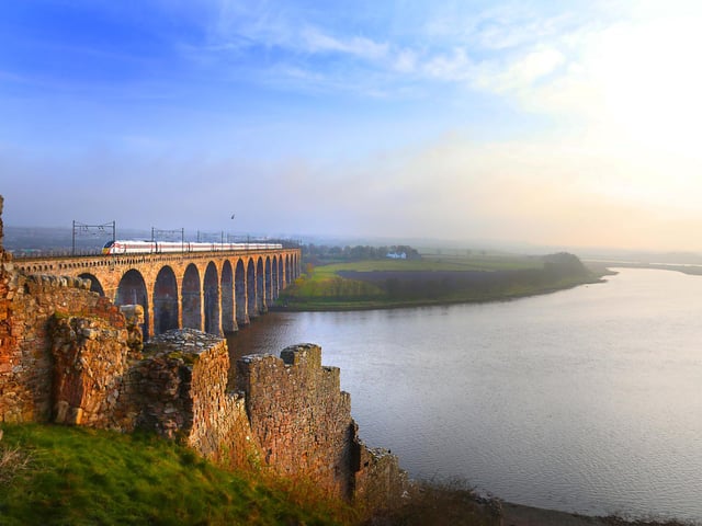 An LNER train passes over the Royal Border Bridge, which spans the River Tweed between Berwick-upon-Tweed and Tweedmouth in Northumberland, England.