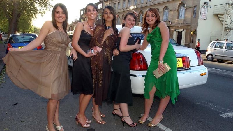 Girls posing in front of a limousine in 2005.