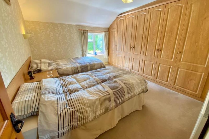 The second bedroom is a double bedroom with a fitted headboard, drawers and a bank of built-in wardrobes with hanging rails, integral drawers and space and connection for a TV.