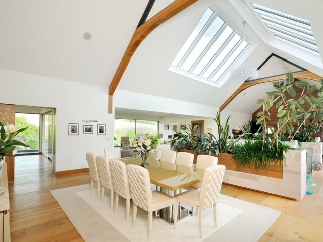 High vaulted ceilings with wooden beams and windows lends the open-plan dining area a bright and airy feel, with plenty of room for both family and guests.